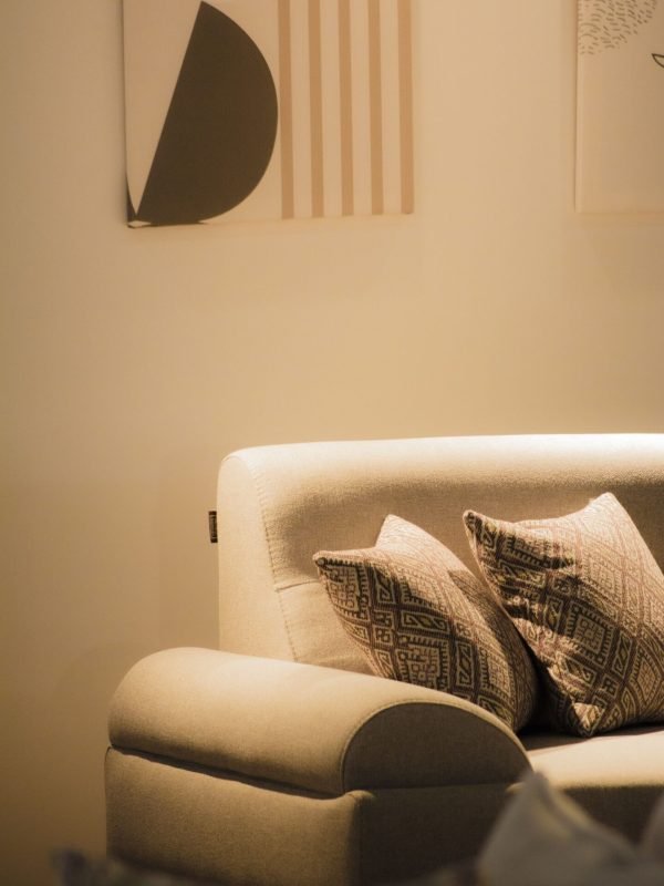 modern-living-room-furniture-sofa Modern beige sofa with patterned cushions in a warm living room with abstract wall art.
